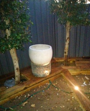 Bunnings pots mounted on a wire cage filled with pebbles and lit with Coleman's light's