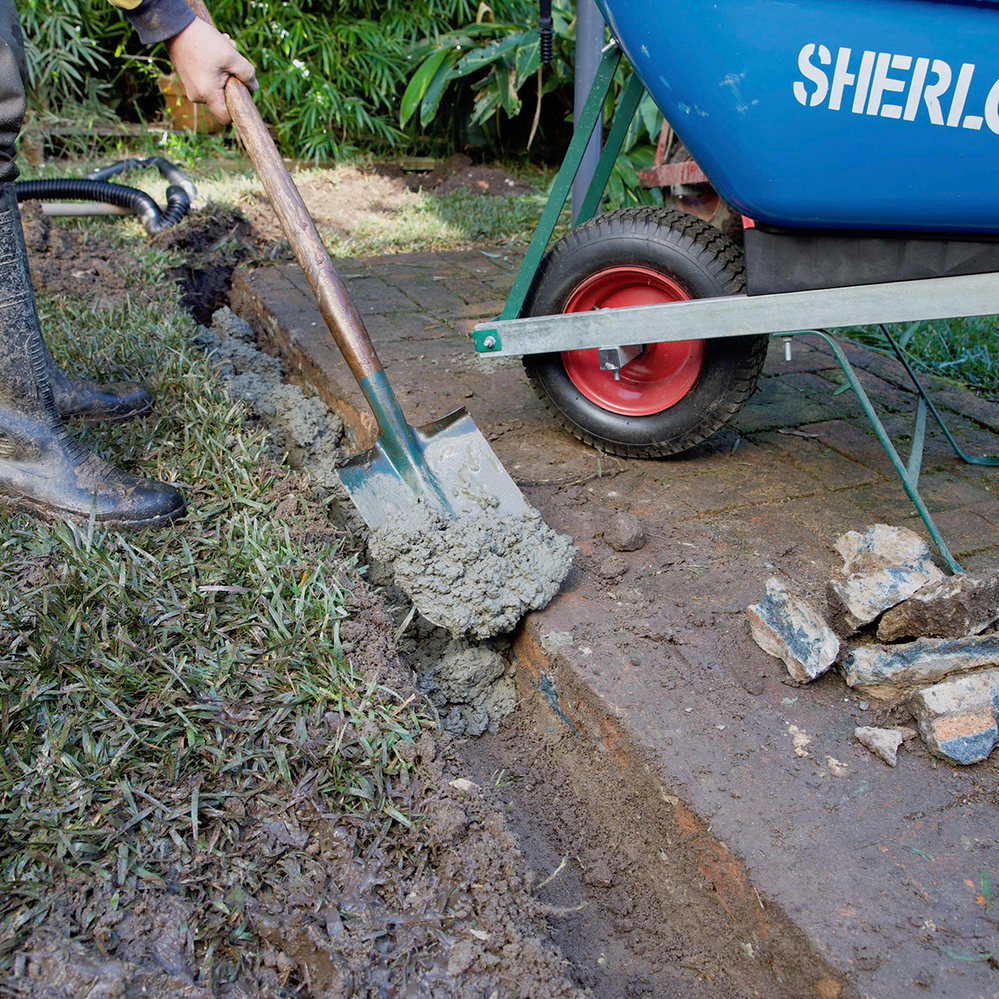 Spread concrete along the base of the trench before adding drain modules