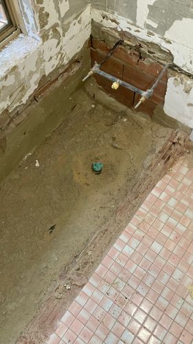 Previous bath location showing concrete slab and floor tiles to right